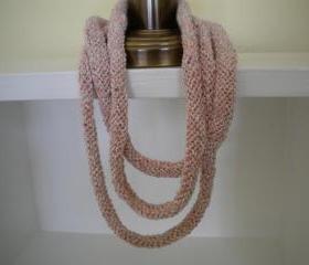 3 strand hand knit necklace of salmon pink and ivory colored yarns.